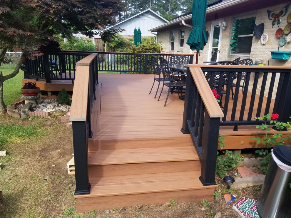 Photo of a mid-sized traditional backyard and ground level deck in Raleigh with no cover and mixed railing.