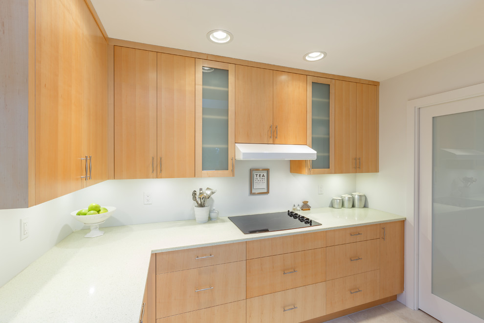 Mid-sized modern l-shaped separate kitchen in Vancouver with an undermount sink, flat-panel cabinets, light wood cabinets, recycled glass benchtops, white splashback, white appliances, porcelain floors and no island.
