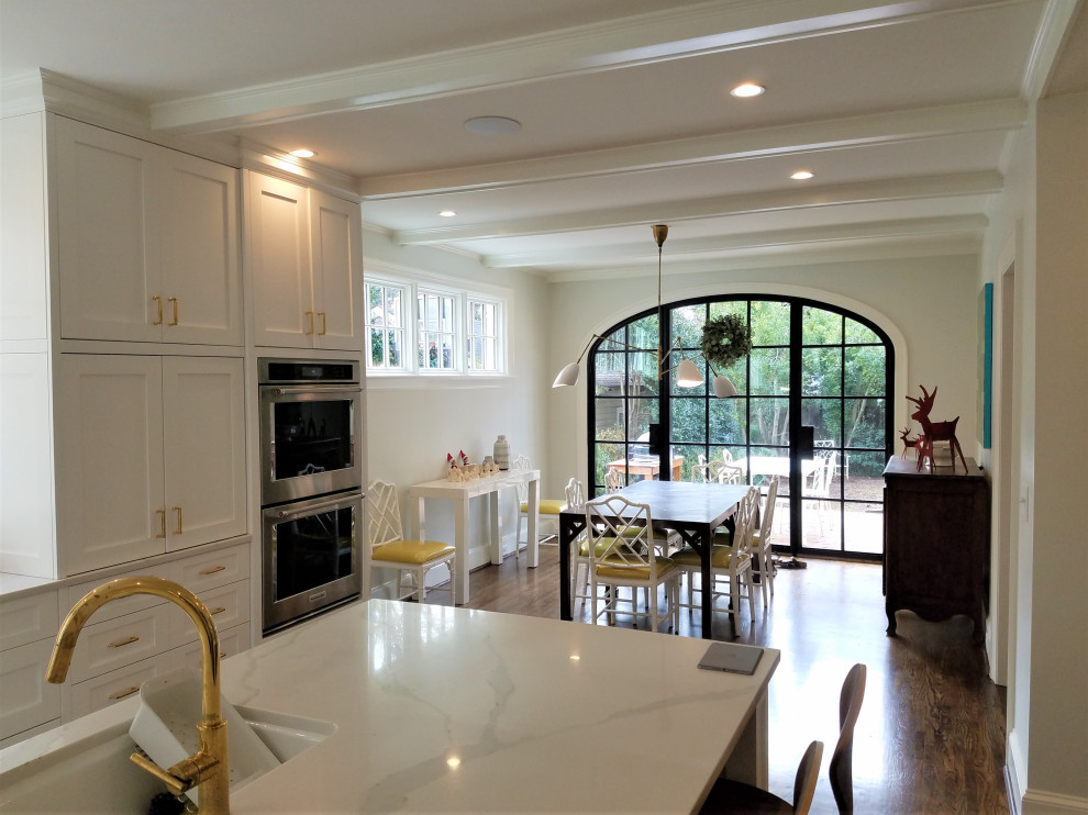 Inspiration for a large contemporary eat-in kitchen in Charlotte with an undermount sink, recessed-panel cabinets, white cabinets, quartzite benchtops, white splashback, ceramic splashback, medium hardwood floors, with island, white benchtop, stainless steel appliances, brown floor and coffered.