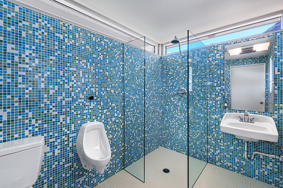 Photo of a mid-sized midcentury bathroom in Other with a curbless shower, an urinal, blue tile, ceramic tile, ceramic floors and a wall-mount sink.