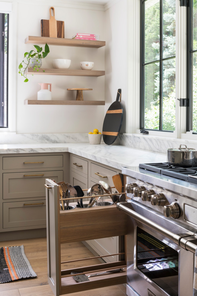 Example of a large transitional light wood floor and beige floor open concept kitchen design in New York with an undermount sink, shaker cabinets, light wood cabinets, marble countertops, white backsplash, marble backsplash, stainless steel appliances, an island and white countertops