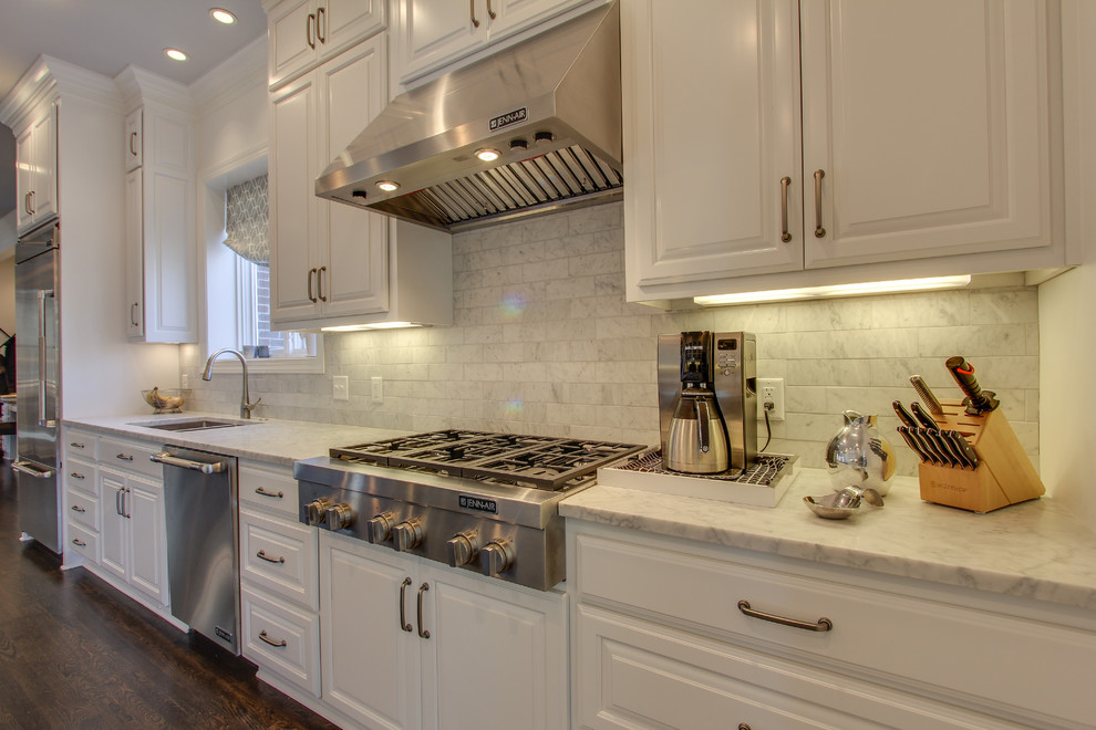 Large contemporary galley eat-in kitchen in Nashville with an undermount sink, raised-panel cabinets, white cabinets, marble benchtops, grey splashback, subway tile splashback, stainless steel appliances and dark hardwood floors.