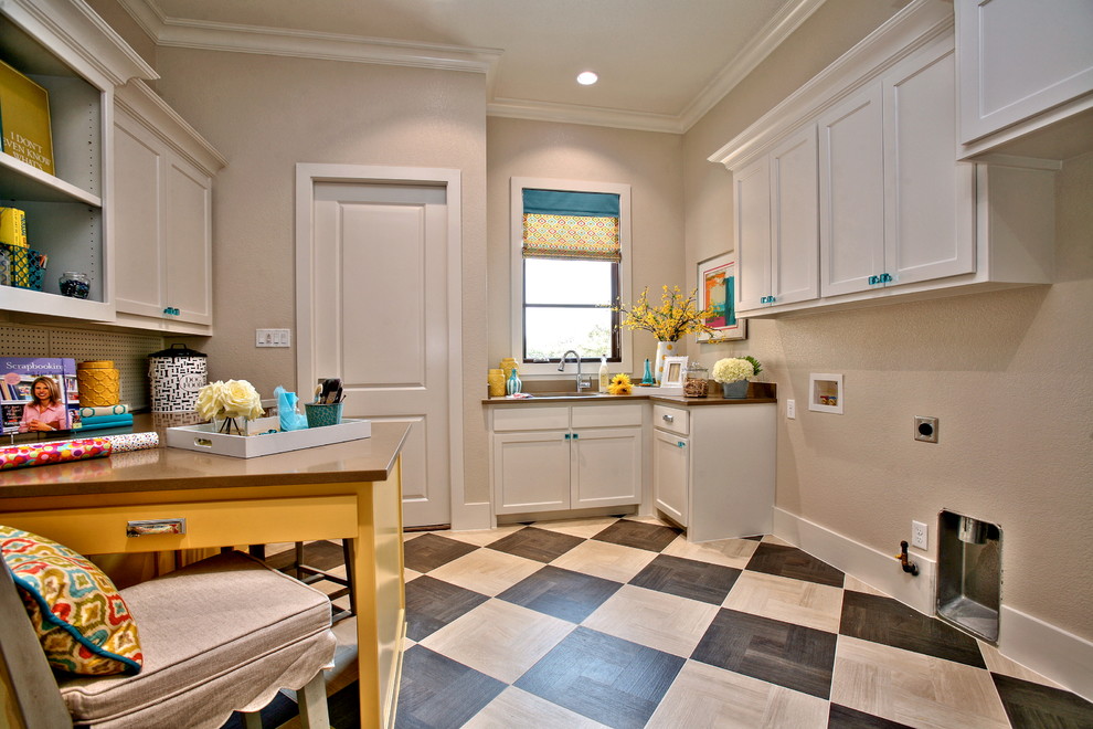 This is an example of a mid-sized transitional galley utility room in Dallas with a drop-in sink, shaker cabinets, white cabinets, solid surface benchtops, beige walls, ceramic floors and a side-by-side washer and dryer.