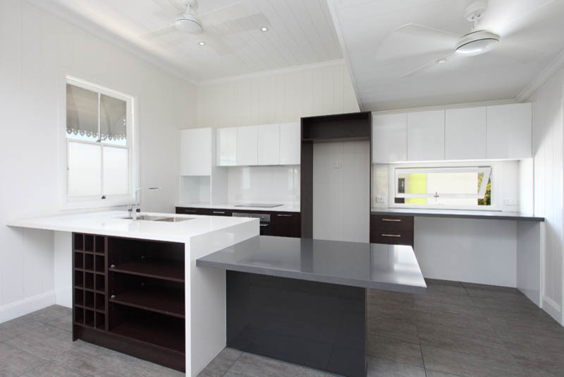 Design ideas for a small traditional galley open plan kitchen in Brisbane with a drop-in sink, flat-panel cabinets, dark wood cabinets, quartz benchtops, white splashback, ceramic splashback, stainless steel appliances, ceramic floors and with island.