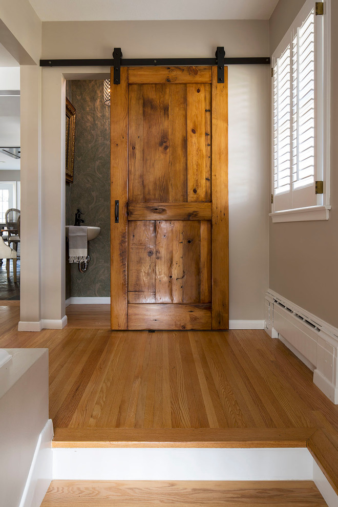Example of a mid-sized mountain style l-shaped slate floor home design design in Minneapolis with a farmhouse sink, shaker cabinets, white cabinets, granite countertops, white backsplash, ceramic backsplash, stainless steel appliances and an island