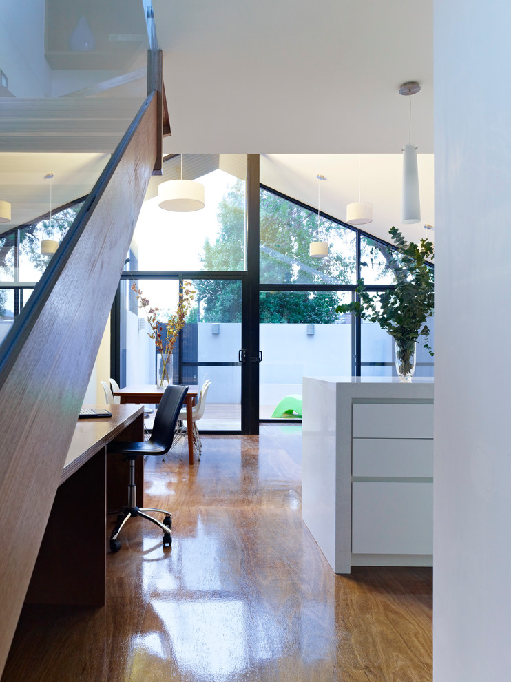 Photo of a small modern open concept family room in Melbourne with white walls, plywood floors and a freestanding tv.