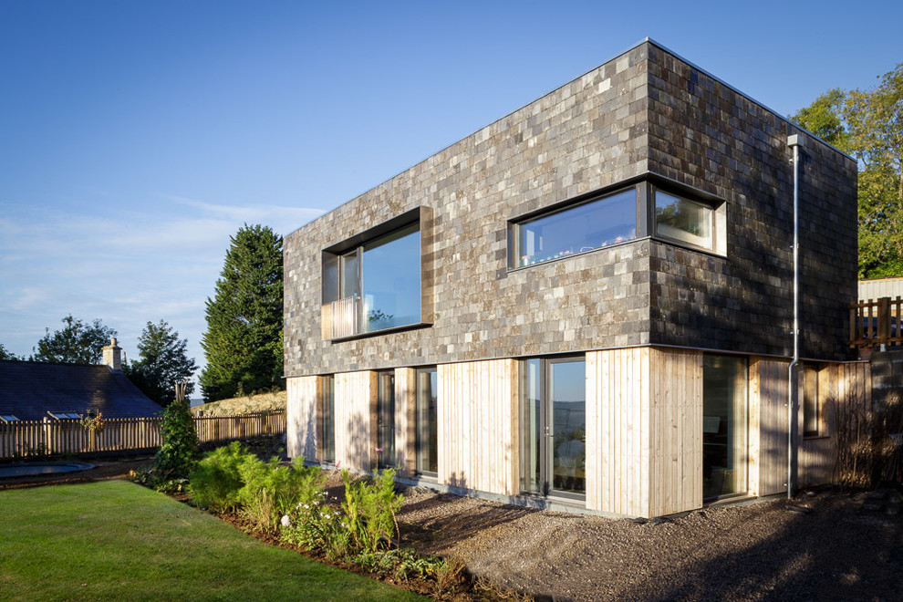 Mid-sized contemporary two-storey exterior in Gloucestershire with mixed siding and a flat roof.