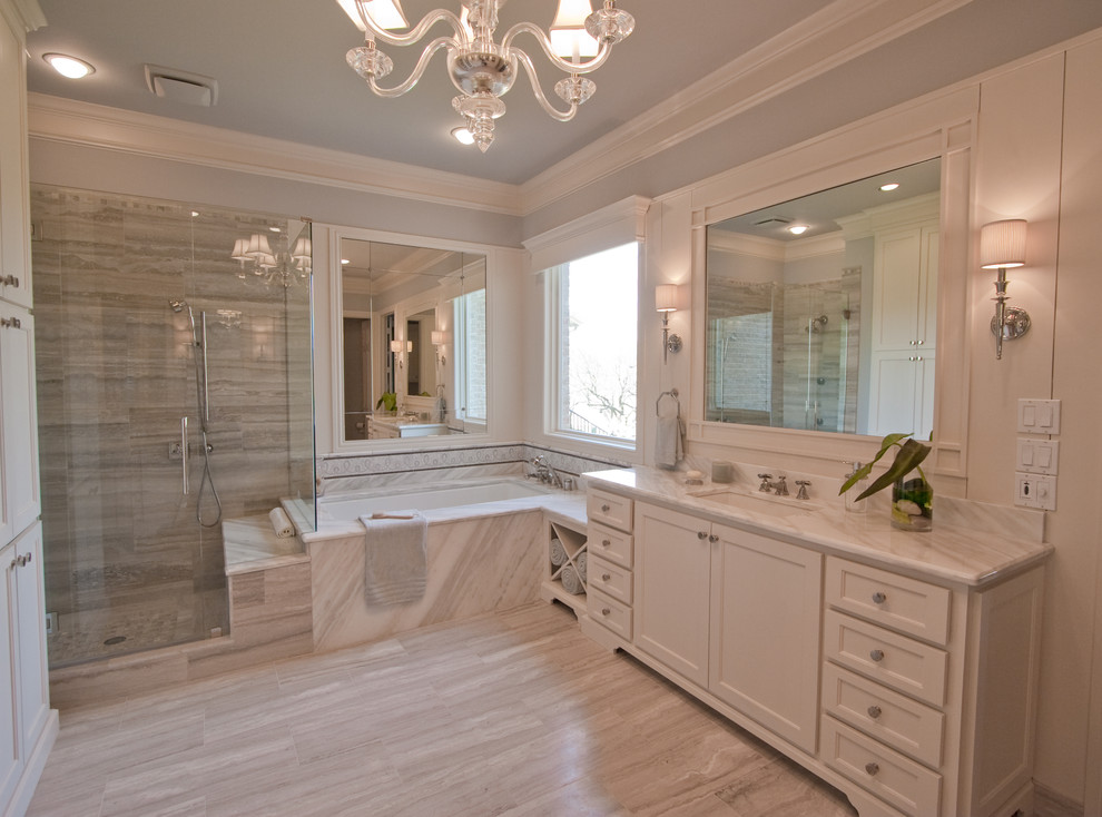 This is an example of a mid-sized transitional master bathroom in Dallas with an undermount sink, shaker cabinets, white cabinets, marble benchtops, an undermount tub, gray tile, blue walls, travertine floors and travertine.