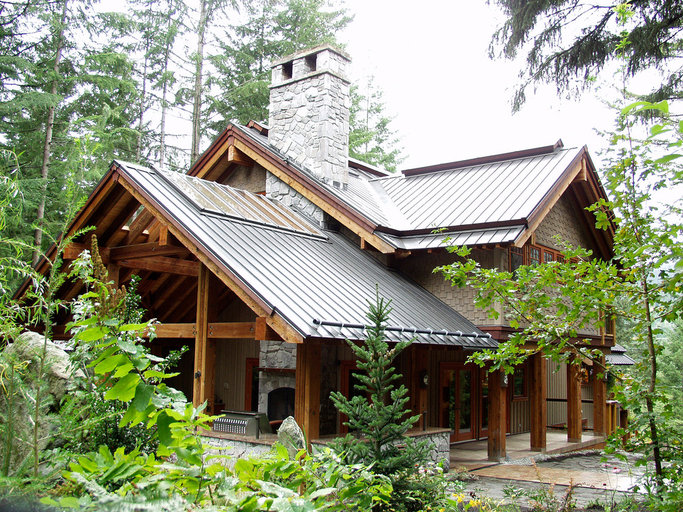 Photo of a country two-storey brown exterior in Vancouver with a metal roof.