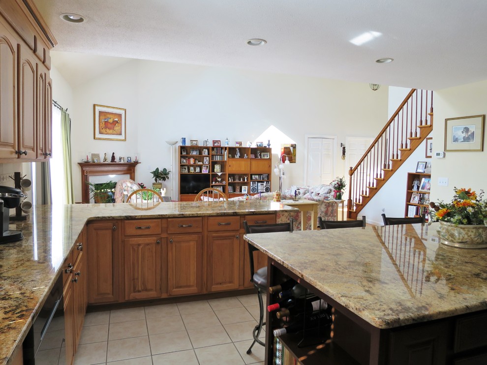 Inspiration for a mid-sized transitional u-shaped ceramic tile and white floor eat-in kitchen remodel in Bridgeport with a double-bowl sink, raised-panel cabinets, light wood cabinets, granite countertops, white backsplash, subway tile backsplash, stainless steel appliances and an island