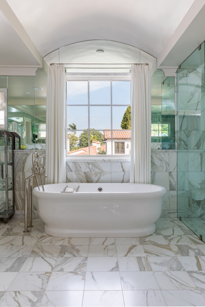 Inspiration for a large coastal master gray tile and marble tile marble floor, gray floor, double-sink and vaulted ceiling bathroom remodel in San Diego with gray cabinets, gray walls, an undermount sink, marble countertops, a hinged shower door, gray countertops and a built-in vanity