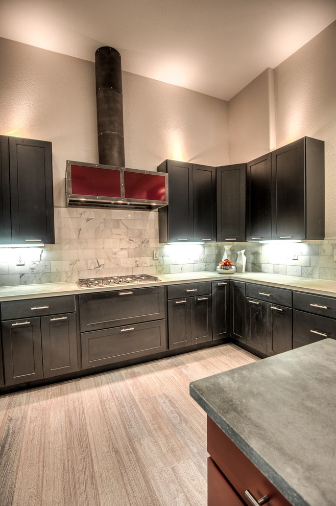 Photo of a mid-sized contemporary u-shaped eat-in kitchen in Sacramento with shaker cabinets, dark wood cabinets, concrete benchtops, grey splashback, stone tile splashback, stainless steel appliances, light hardwood floors and with island.