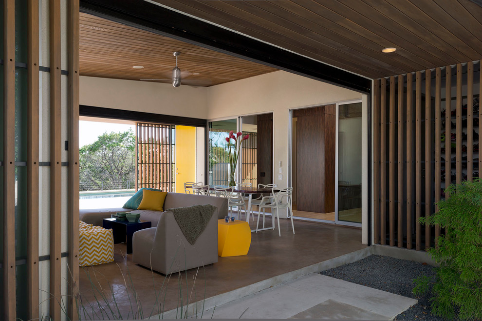 Inspiration for a midcentury patio in Austin with concrete slab and a roof extension.