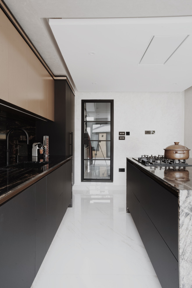 Medium sized contemporary single-wall kitchen/diner in London with a submerged sink, flat-panel cabinets, black cabinets, granite worktops, black splashback, black appliances, porcelain flooring, an island, white floors and black worktops.