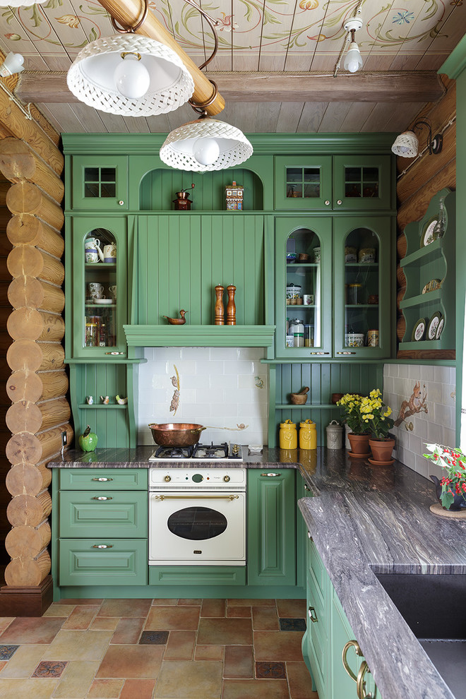 Photo of a country l-shaped kitchen in Moscow with an undermount sink, glass-front cabinets, green cabinets, white splashback, white appliances, multi-coloured floor and grey benchtop.