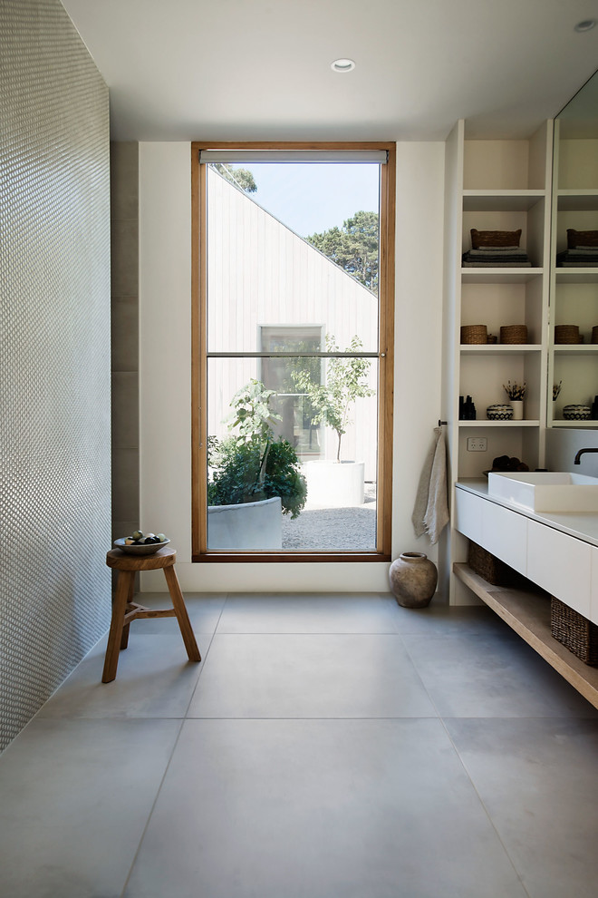 Inspiration for a mid-sized contemporary master bathroom in Melbourne with open cabinets, white cabinets, an alcove shower, green tile, pebble tile, white walls, porcelain floors, an undermount sink, solid surface benchtops, grey floor, a sliding shower screen and beige benchtops.