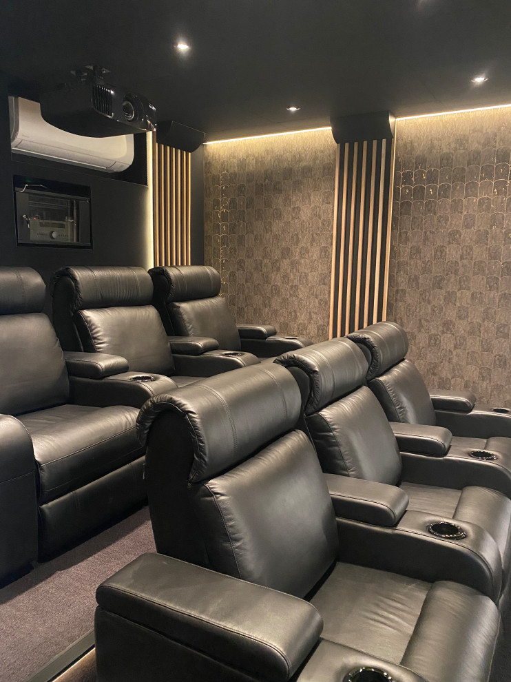 This is an example of a large country enclosed home cinema in Montpellier with black walls, carpet and black floors.