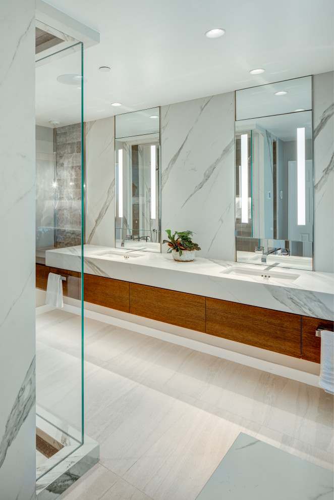 Example of a large trendy master stone slab porcelain tile and double-sink bathroom design in Seattle with flat-panel cabinets, medium tone wood cabinets, an undermount sink, solid surface countertops, a hinged shower door and a floating vanity