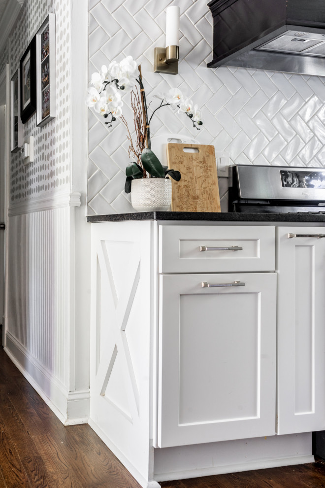 Exempel på ett mellanstort modernt svart svart kök, med en undermonterad diskho, skåp i shakerstil, vita skåp, granitbänkskiva, vitt stänkskydd, stänkskydd i keramik, rostfria vitvaror, mellanmörkt trägolv, en köksö och brunt golv