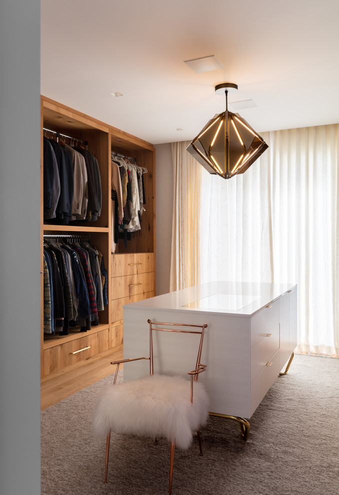 This is an example of a large contemporary gender-neutral dressing room in Other with flat-panel cabinets, medium wood cabinets, brown floor and light hardwood floors.