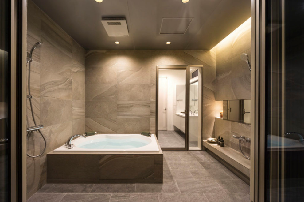 モダンスタイルのおしゃれな浴室 (ドロップイン型浴槽、ベージュのタイル、ベージュの壁、ベージュの床、折り上げ天井) の写真