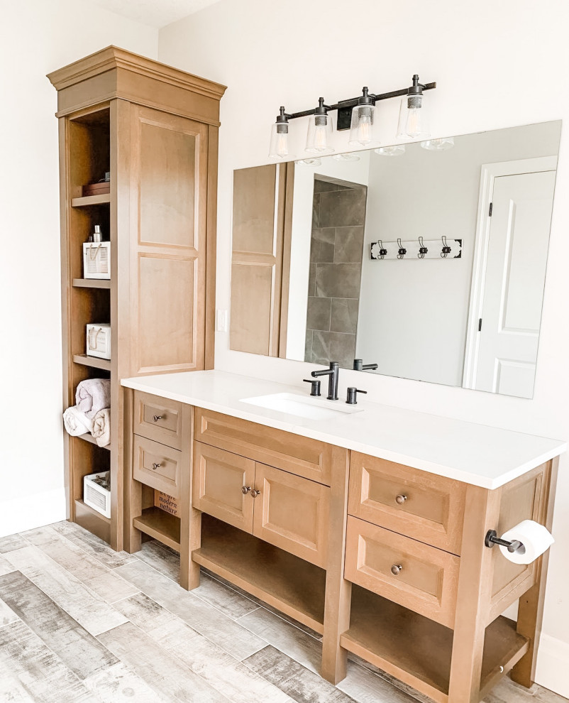This is an example of a large rural ensuite bathroom in Chicago with freestanding cabinets, light wood cabinets, a freestanding bath, a two-piece toilet, beige walls, wood-effect flooring, a submerged sink, engineered stone worktops, brown floors, beige worktops, a single sink, a freestanding vanity unit and a vaulted ceiling.