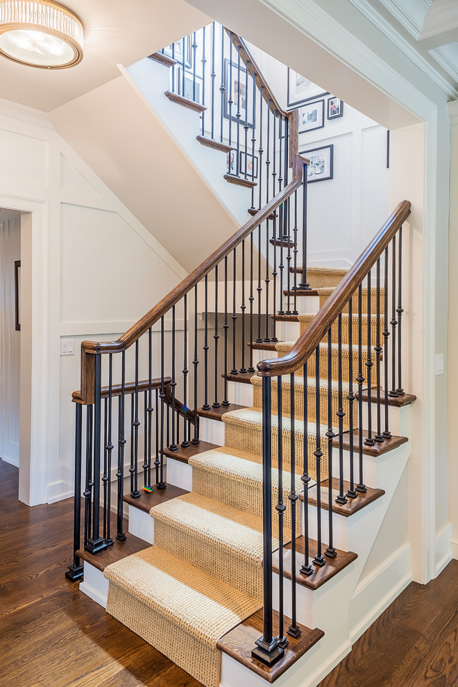 Expansive traditional wood u-shaped staircase in Chicago with wood risers and metal railing.