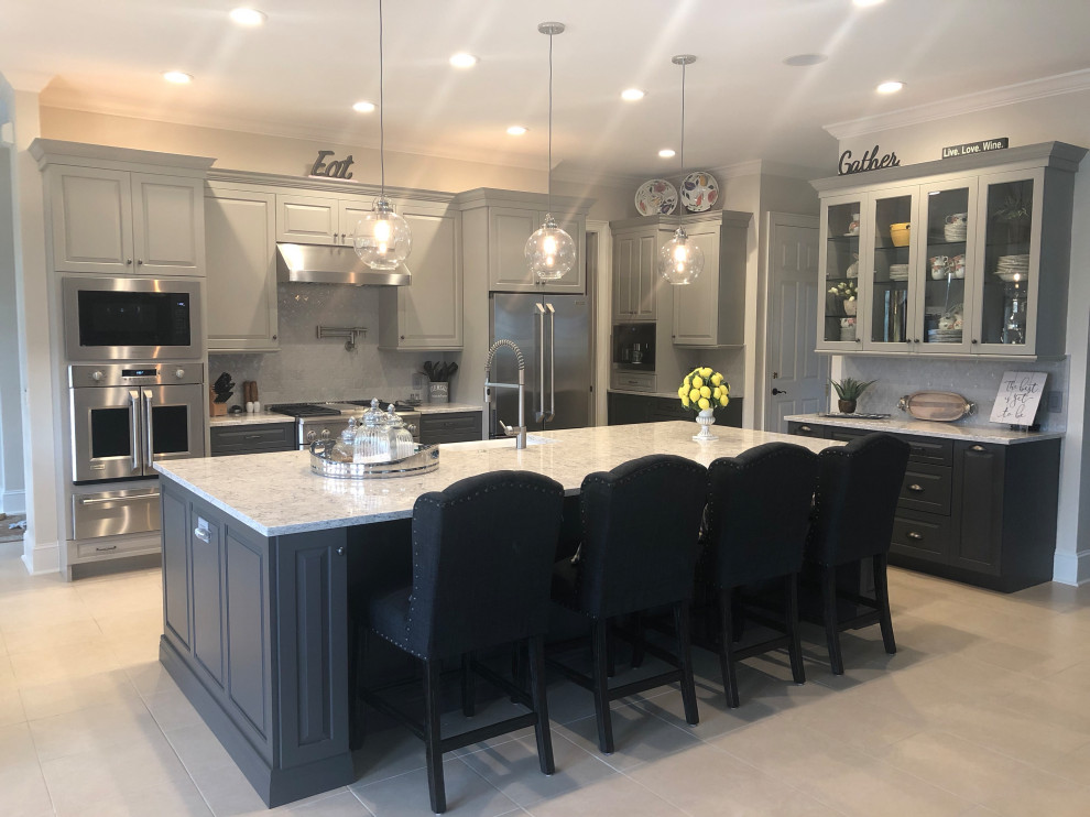 Inspiration for a transitional porcelain tile and beige floor kitchen remodel with a single-bowl sink, raised-panel cabinets, gray cabinets, quartz countertops, gray backsplash, ceramic backsplash and stainless steel appliances