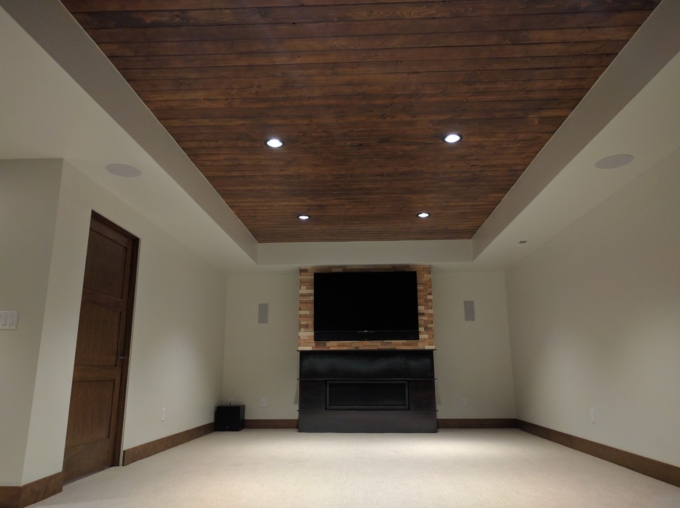 This is an example of a mid-sized arts and crafts open concept home theatre in Denver with green walls, carpet, a wall-mounted tv and beige floor.