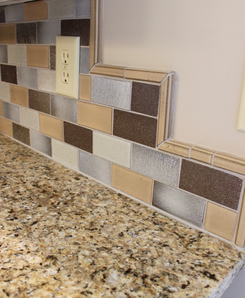 Example of a transitional single-wall staircase design in Cincinnati with granite countertops, multicolored backsplash and subway tile backsplash
