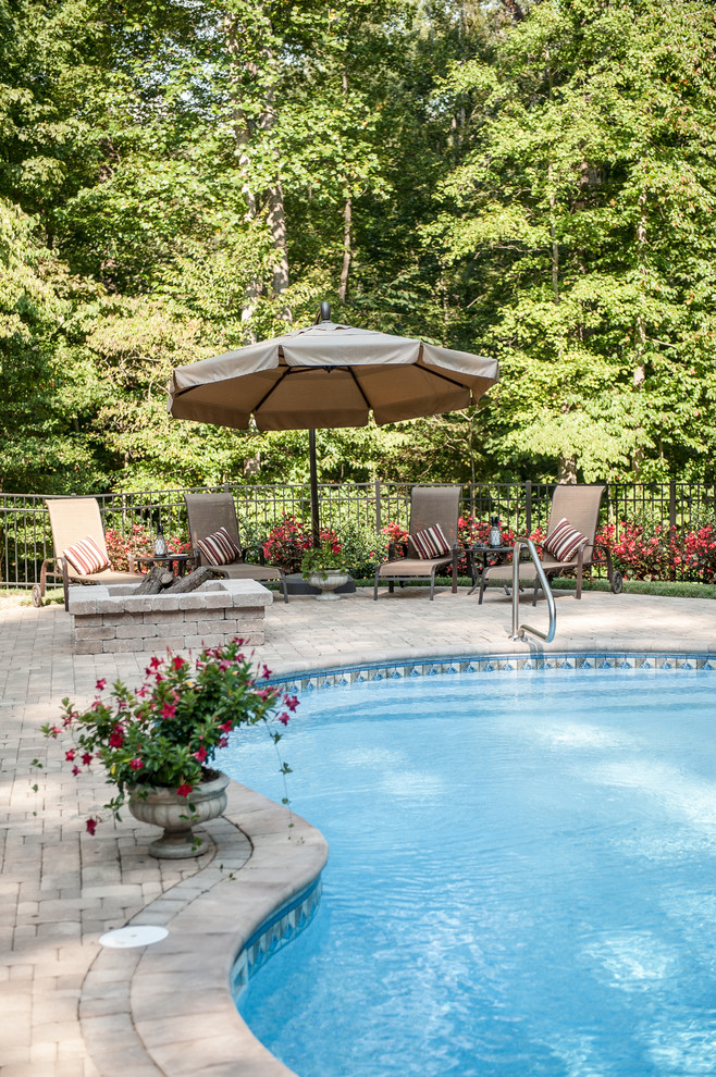 Design ideas for a large traditional backyard pool in Richmond with brick pavers.