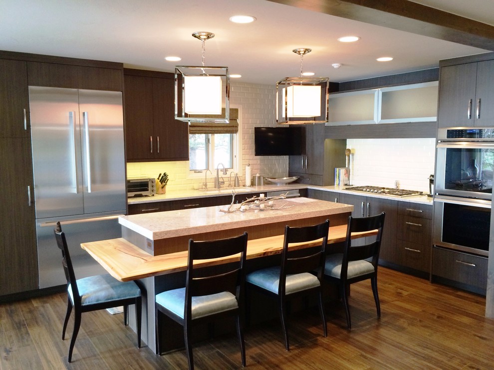 Mid-sized transitional l-shaped dark wood floor and brown floor open concept kitchen photo in Denver with an undermount sink, flat-panel cabinets, dark wood cabinets, granite countertops, white backsplash, subway tile backsplash, stainless steel appliances and an island
