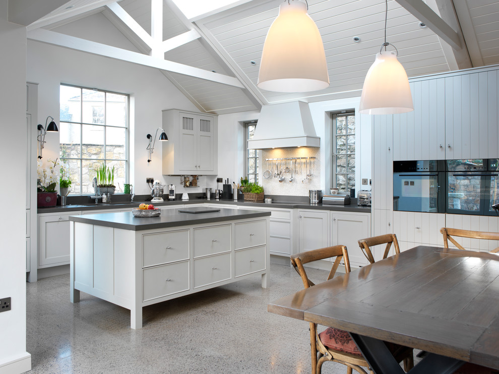 Photo of a contemporary eat-in kitchen in Dublin with recessed-panel cabinets and white cabinets.