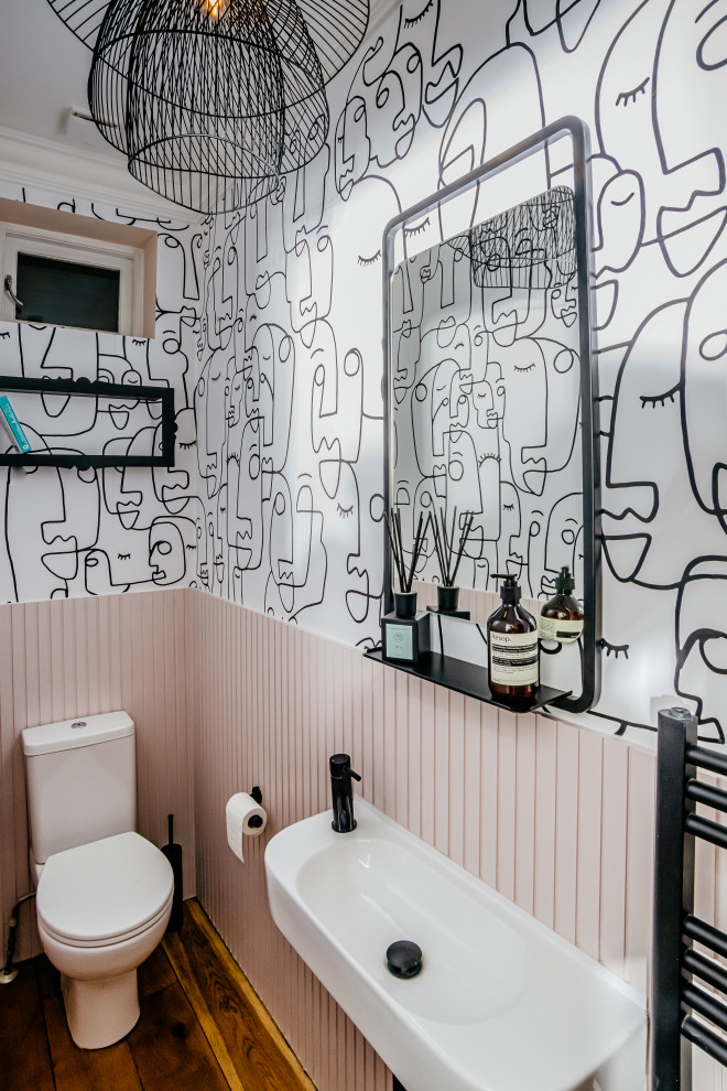 Idee per un piccolo bagno di servizio minimal con pareti rosa, lavabo sospeso, mobile bagno sospeso e carta da parati