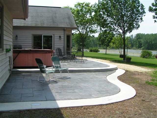 Design ideas for a mid-sized modern backyard patio in Milwaukee with natural stone pavers and no cover.