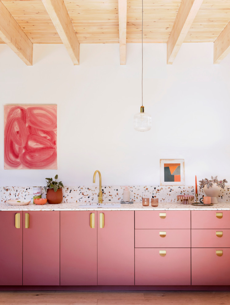 Источник вдохновения для домашнего уюта: маленькая прямая кухня-гостиная: освещение в средиземноморском стиле с одинарной мойкой, плоскими фасадами, розовыми фасадами, столешницей терраццо, разноцветным фартуком, фартуком из мрамора, светлым паркетным полом и разноцветной столешницей без острова для на участке и в саду