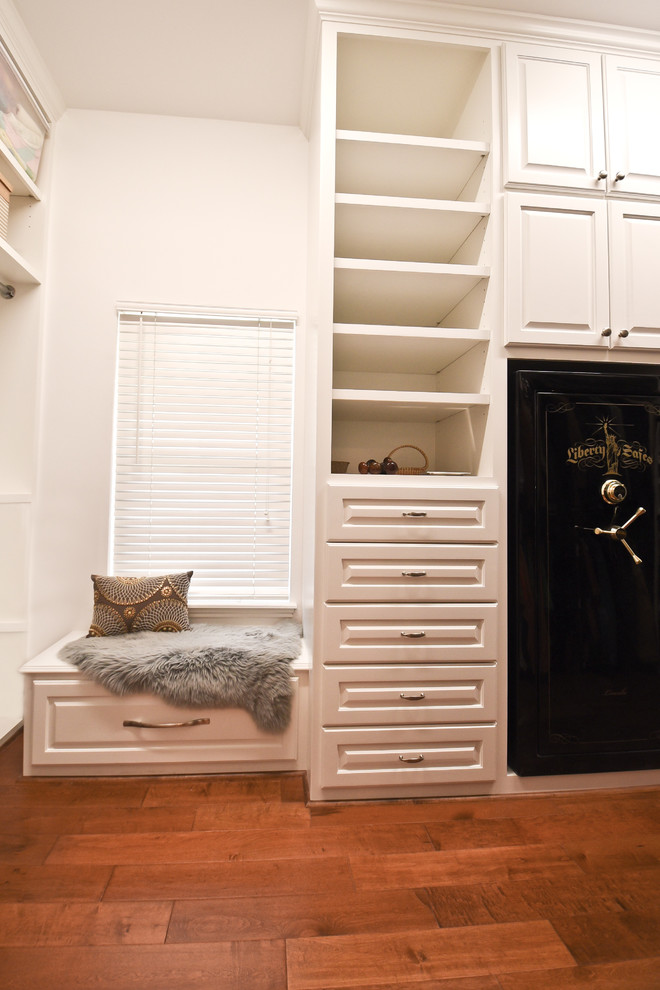 Photo of a traditional walk-in wardrobe in Houston with raised-panel cabinets, white cabinets and medium hardwood floors.