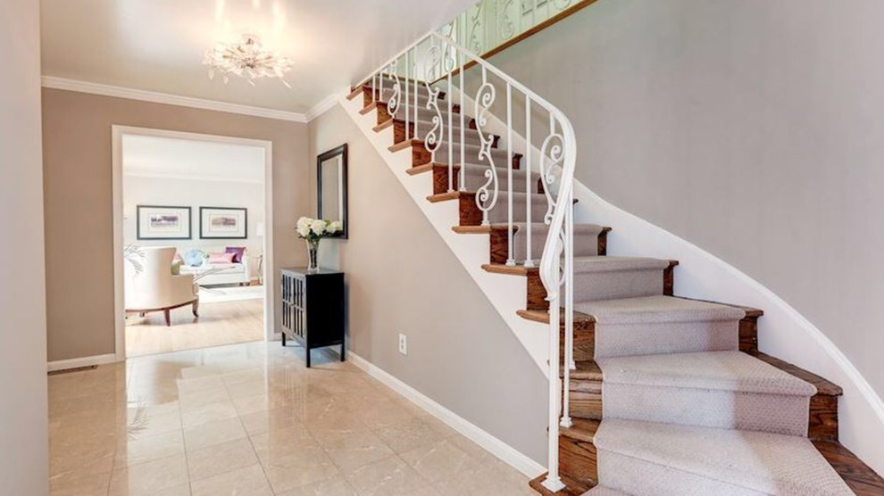 Design ideas for a large traditional carpeted curved staircase in DC Metro with carpet risers and metal railing.