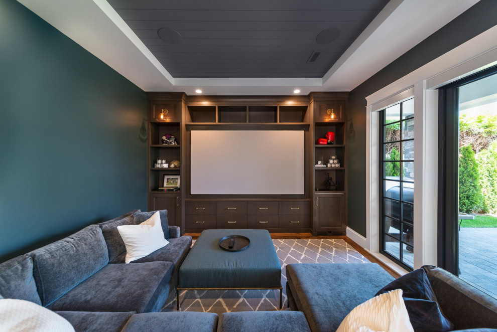 Mid-sized arts and crafts enclosed home theatre in Vancouver with green walls, dark hardwood floors, a projector screen and brown floor.