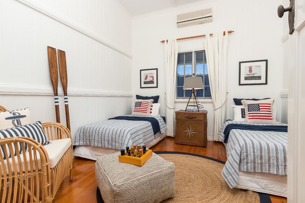 Beach style kids' bedroom in Brisbane with white walls, medium hardwood floors and brown floor for kids 4-10 years old and boys.