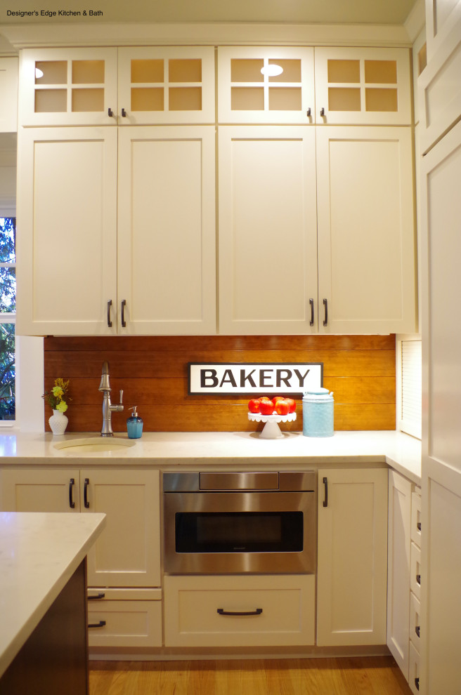 Large arts and crafts galley eat-in kitchen in Portland with an undermount sink, shaker cabinets, white cabinets, quartz benchtops, shiplap splashback, stainless steel appliances, medium hardwood floors, with island and white benchtop.