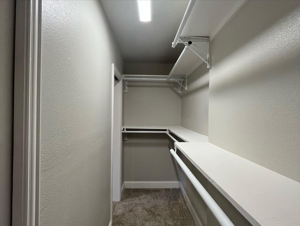 Exempel på ett mellanstort klassiskt walk-in-closet för könsneutrala, med vita skåp, heltäckningsmatta och beiget golv