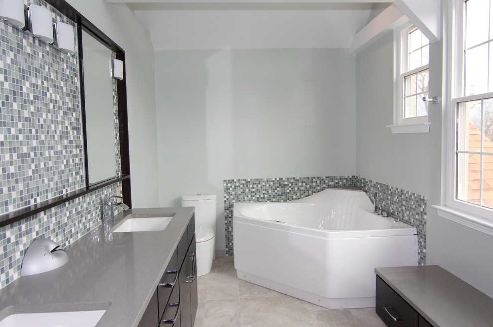 Photo of a large contemporary master bathroom in Philadelphia with an undermount sink, flat-panel cabinets, dark wood cabinets, quartzite benchtops, a corner tub, a corner shower, a one-piece toilet, gray tile, porcelain tile, blue walls and porcelain floors.