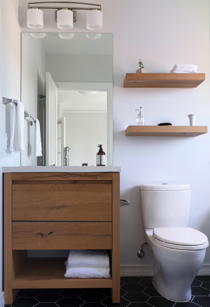 Design ideas for a small transitional bathroom in San Francisco with furniture-like cabinets, light wood cabinets, a curbless shower, a two-piece toilet, white tile, ceramic tile, white walls, ceramic floors, an undermount sink, concrete benchtops, black floor, an open shower and white benchtops.