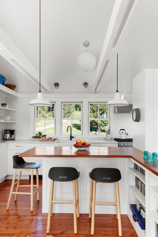 Design ideas for a small country galley open plan kitchen in Boston with a peninsula, white cabinets, quartzite benchtops, white benchtop, a farmhouse sink, white splashback, stainless steel appliances, medium hardwood floors, exposed beam, shaker cabinets and brown floor.