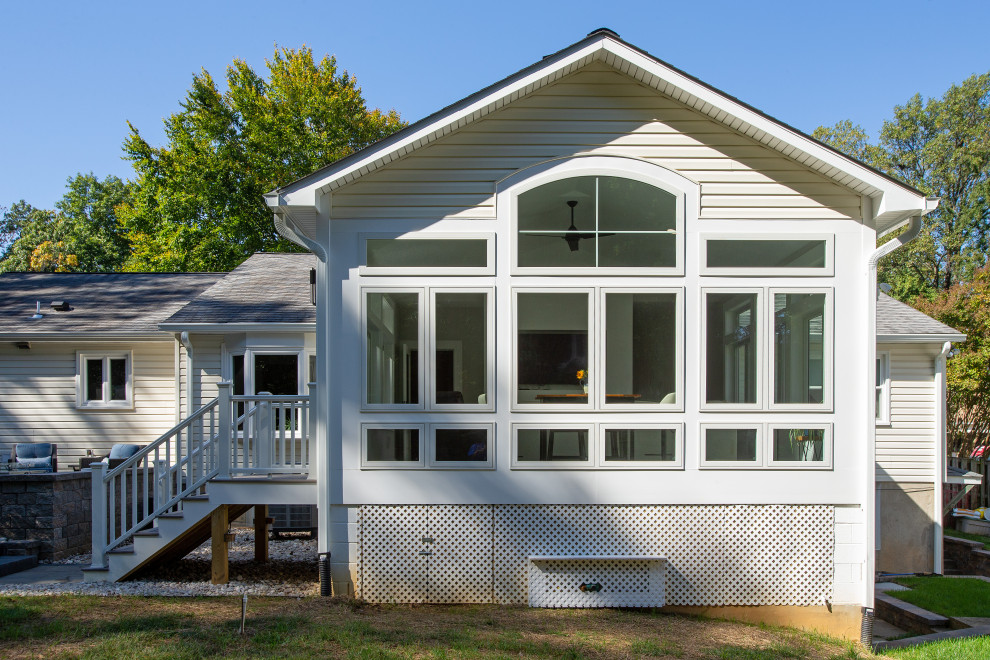 Large and white traditional bungalow detached house in DC Metro with vinyl cladding, a pitched roof, a shingle roof, a grey roof and board and batten cladding.