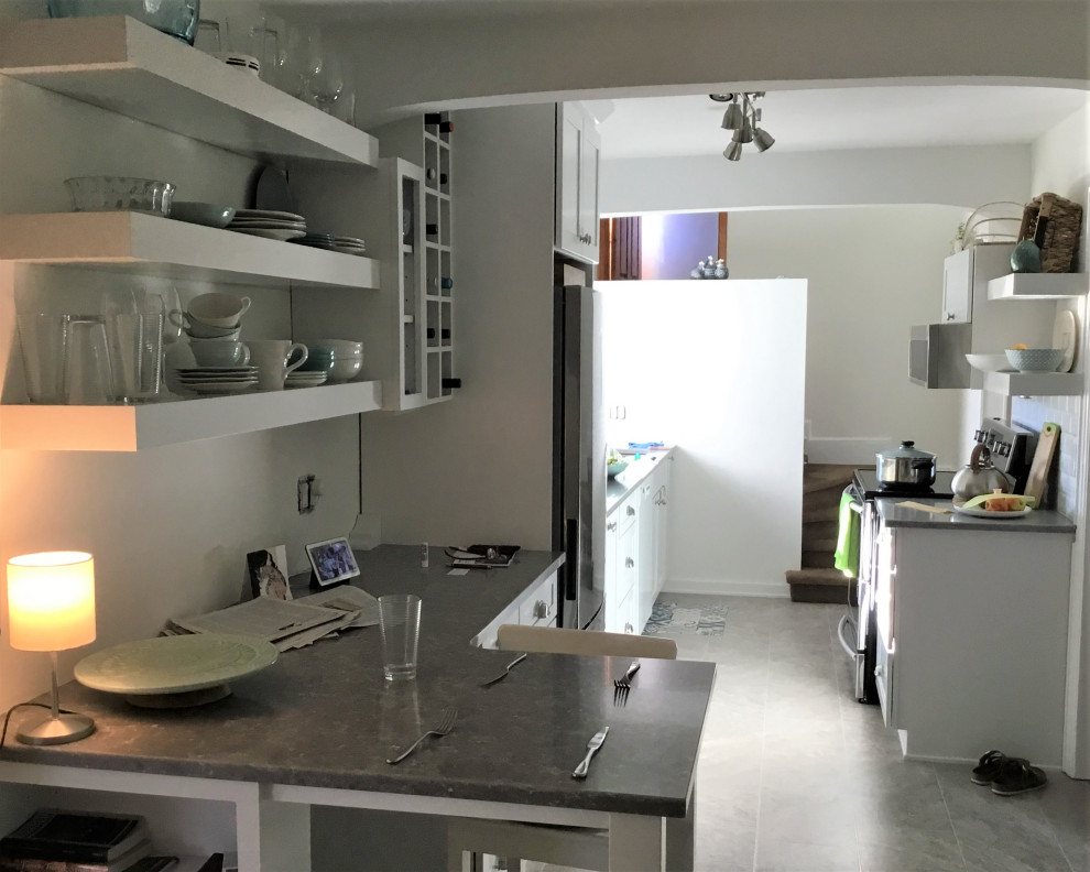 Eat-in kitchen - mid-sized transitional galley ceramic tile and gray floor eat-in kitchen idea with an undermount sink, shaker cabinets, white cabinets, quartz countertops, white backsplash, subway tile backsplash, stainless steel appliances, a peninsula and gray countertops