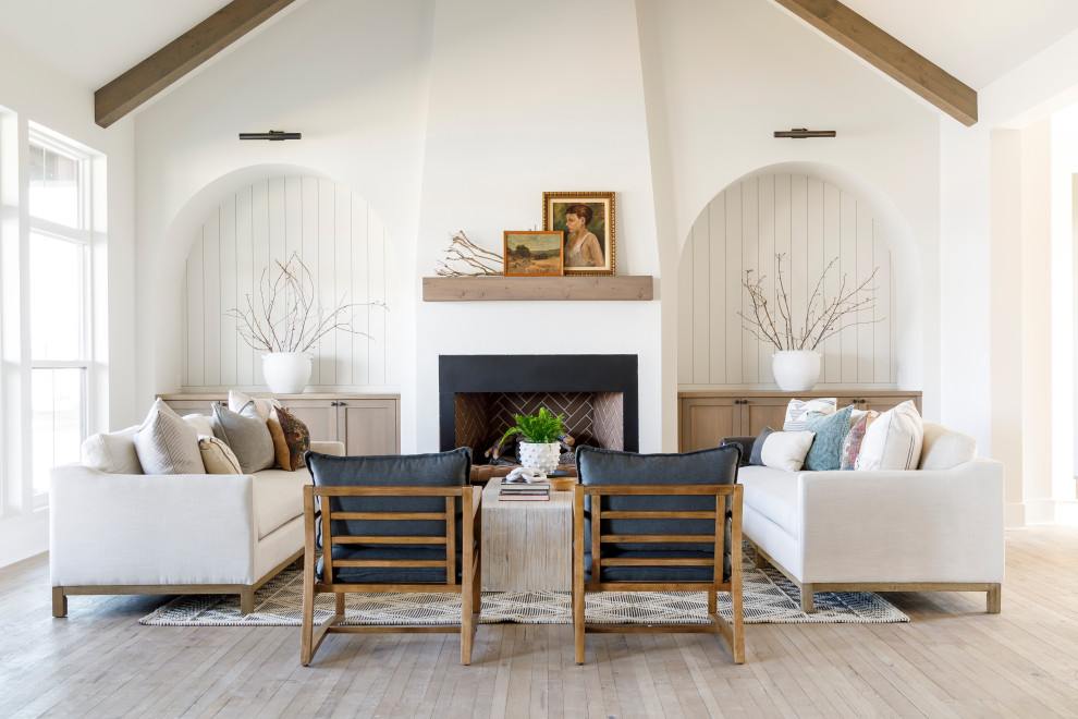 Mittelgroßes Landhaus Wohnzimmer mit weißer Wandfarbe, braunem Holzboden, Kamin, verputzter Kaminumrandung, gewölbter Decke, Holzdielenwänden und Rundbogen in Boise