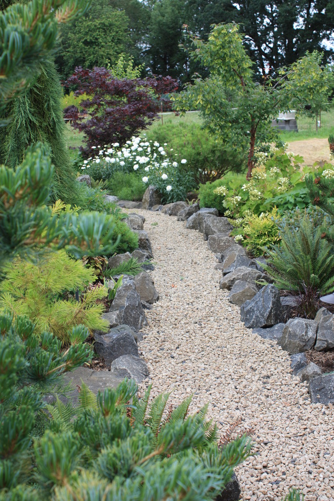 This is an example of a large traditional backyard full sun garden in Other with gravel and a garden path.