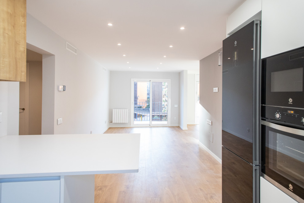 Mittelgroßes, Offenes Modernes Wohnzimmer ohne Kamin mit beiger Wandfarbe, braunem Holzboden und braunem Boden in Barcelona
